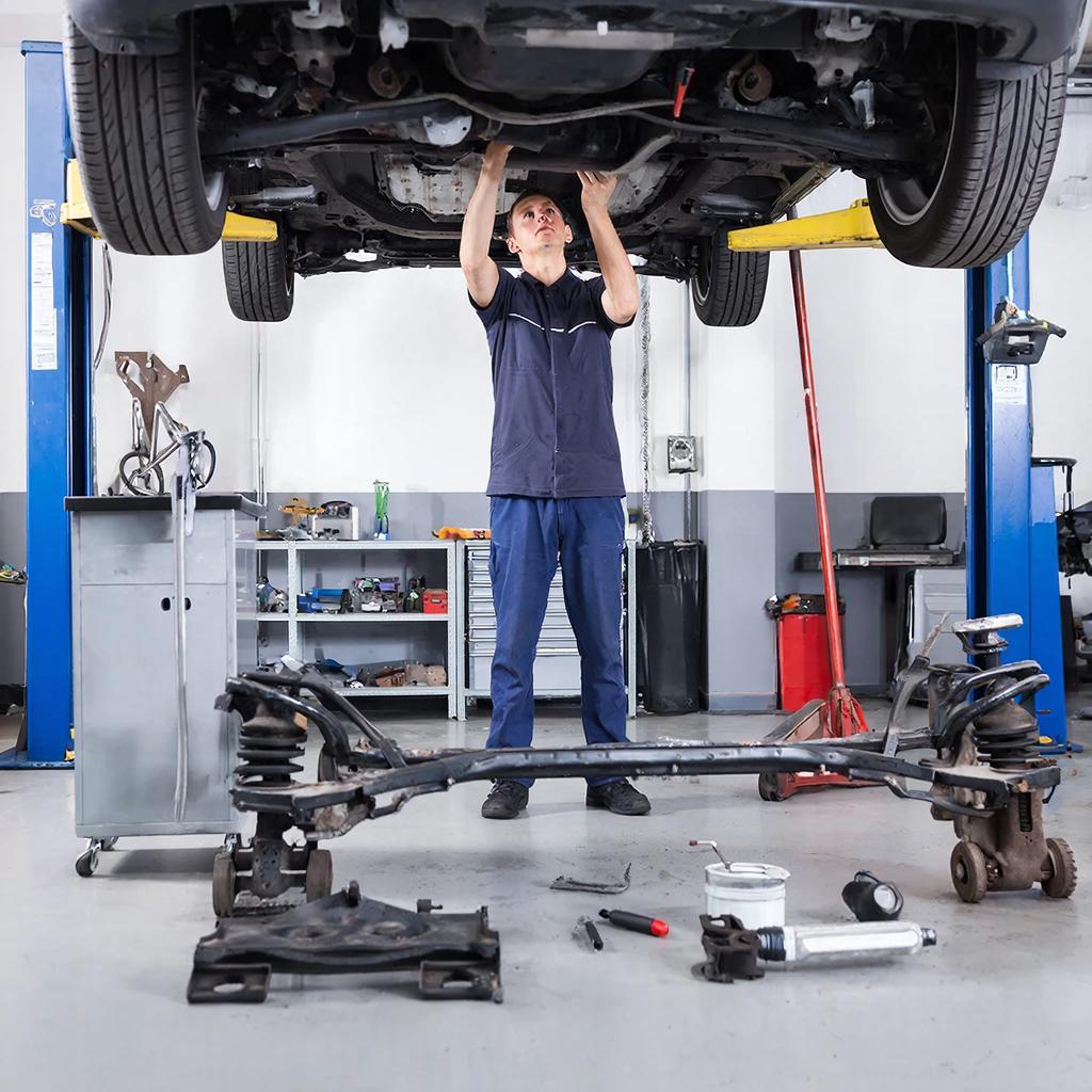 Механик ремонтирует подвеску автомобиля