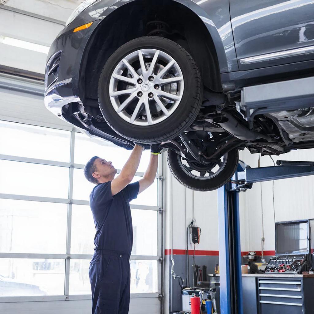 Мастер проверяет подвеску автомобиля