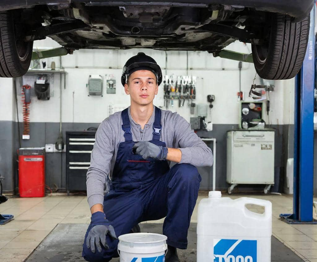 Мастер меняет масло в двигателе автомобиля