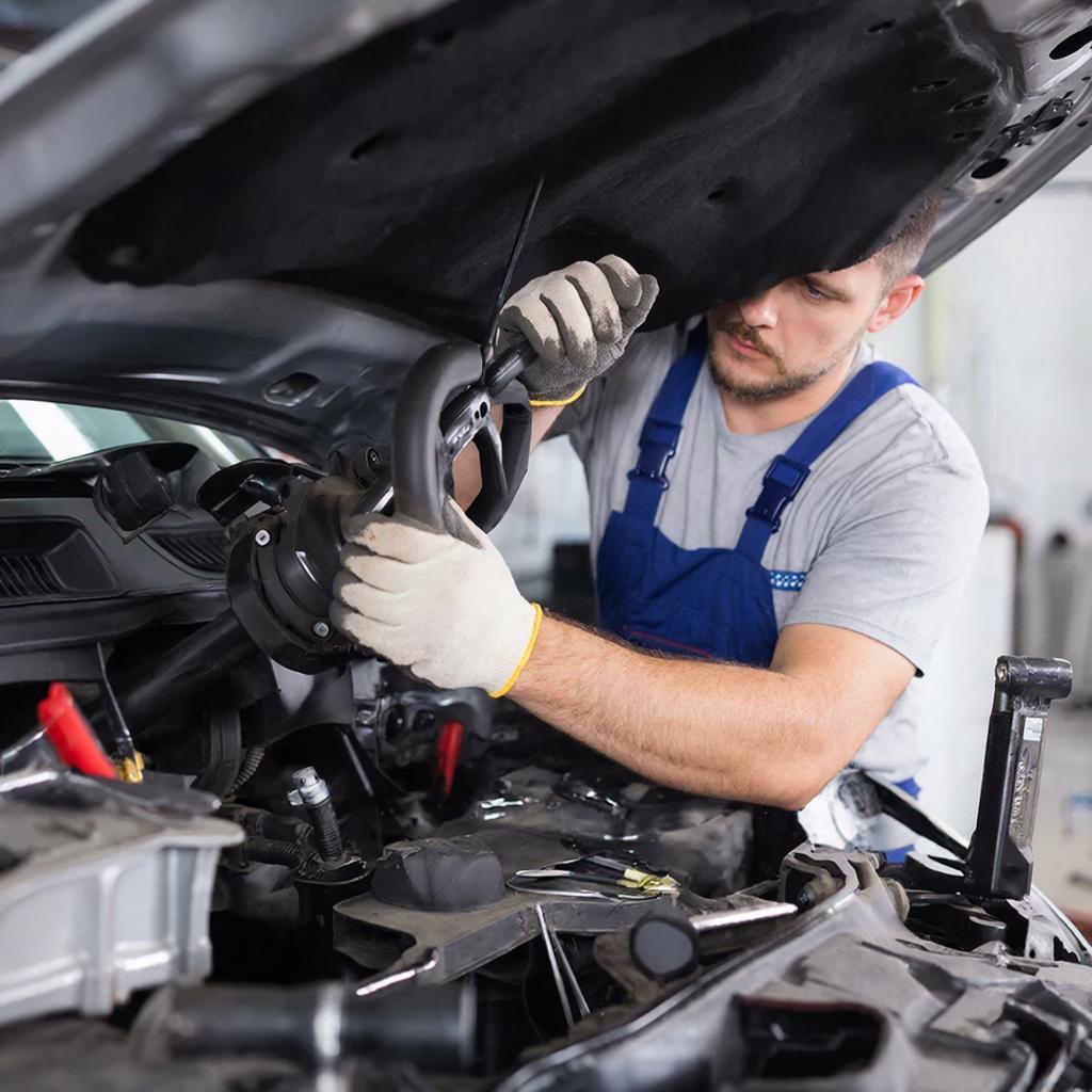 Автомеханик меняет переднее  тормозные колодки автомобиля